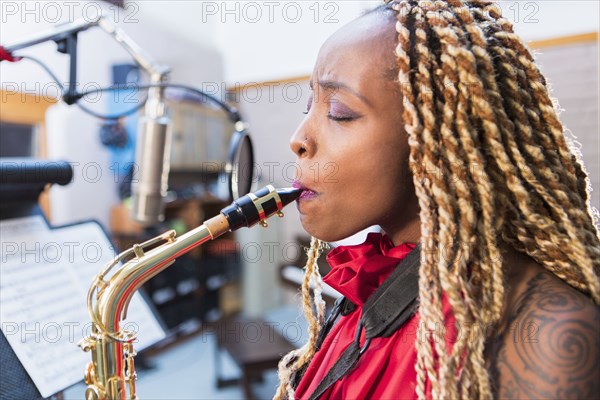 African American saxophone player recording in studio