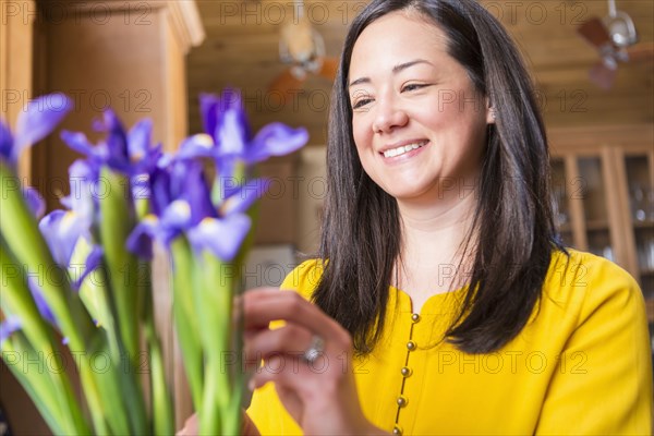 Mixed race woman arranging flowers