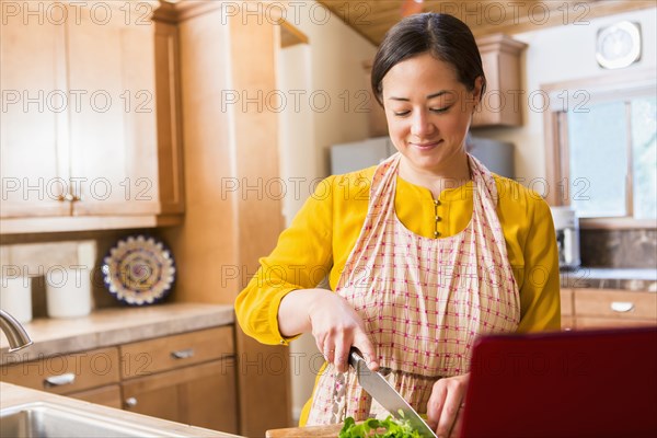 Mixed race woman cooking in kitchen