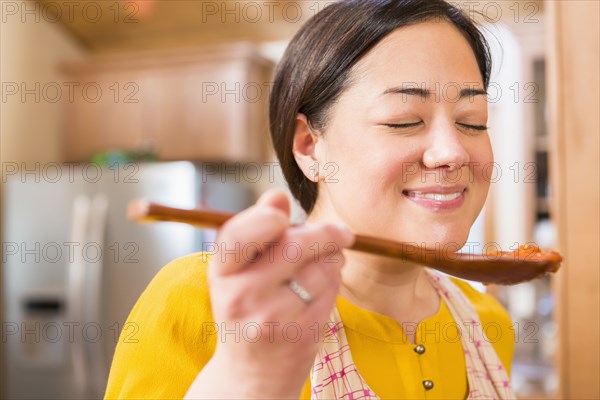 Mixed race woman cooking in kitchen