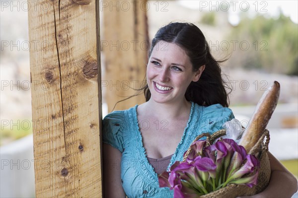 Caucasian woman holding basket of groceries