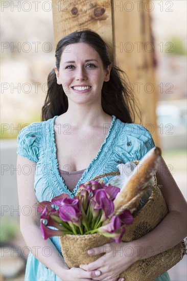 Caucasian woman holding basket of groceries