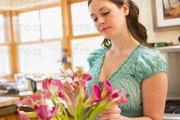 Caucasian woman holding vase of flowers