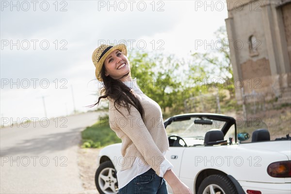 Caucasian woman smiling by convertible