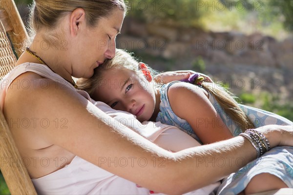 Caucasian mother and daughter relaxing outdoors