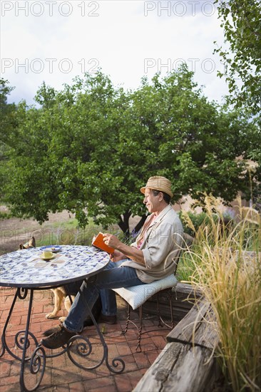 Caucasian man reading at table outdoors