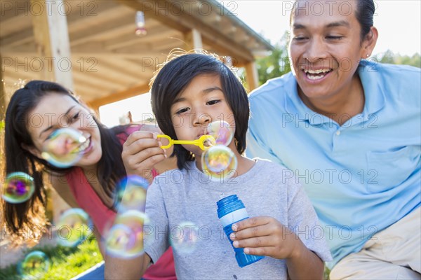 Family blowing bubbles outdoors