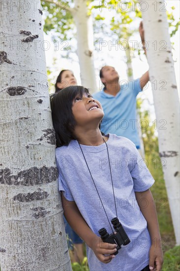 Boy with binoculars in forest