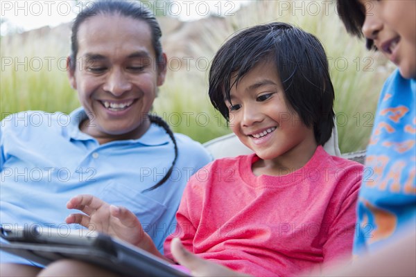 Family using digital tablet outdoors