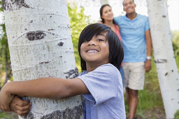 Boy hugging tree outdoors