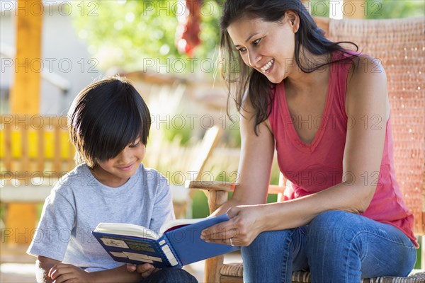 Mother and son reading together on porch