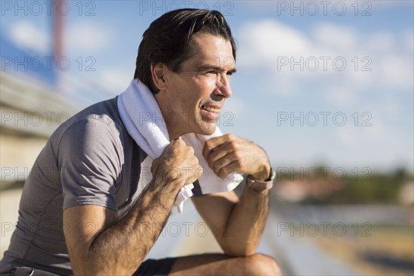Hispanic man resting with towel around neck