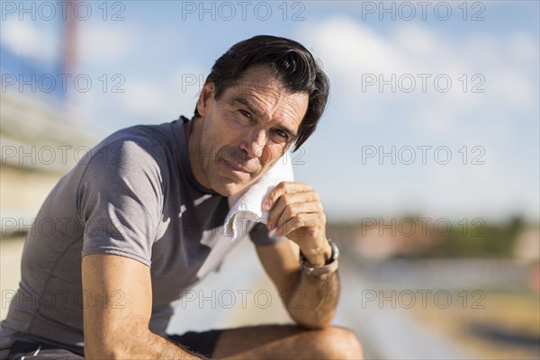 Hispanic man resting with towel around neck