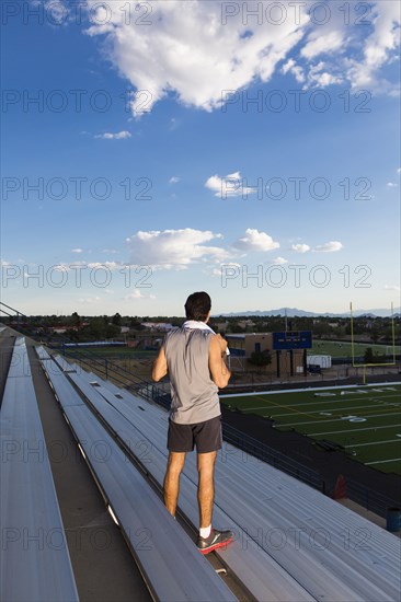 Hispanic athlete standing on bleachers