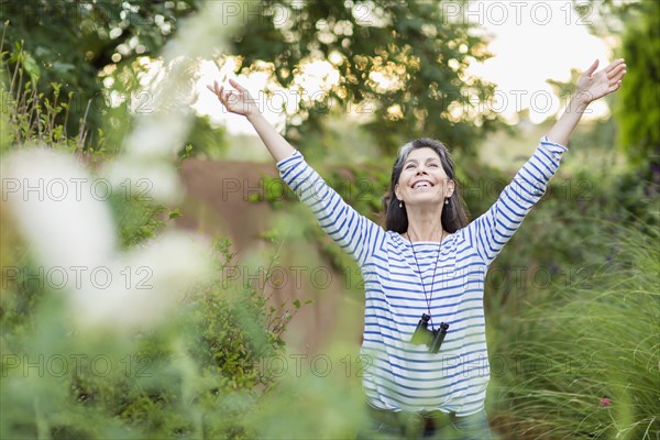 Hispanic woman standing with arms outstretched outdoors