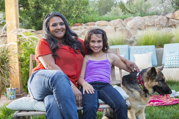 Mother and daughter relaxing in backyard