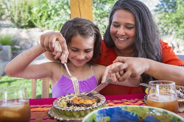 Mother and daughter eating at table