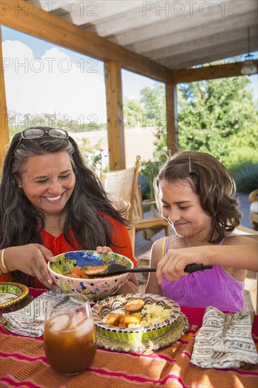 Mother and daughter eating at table