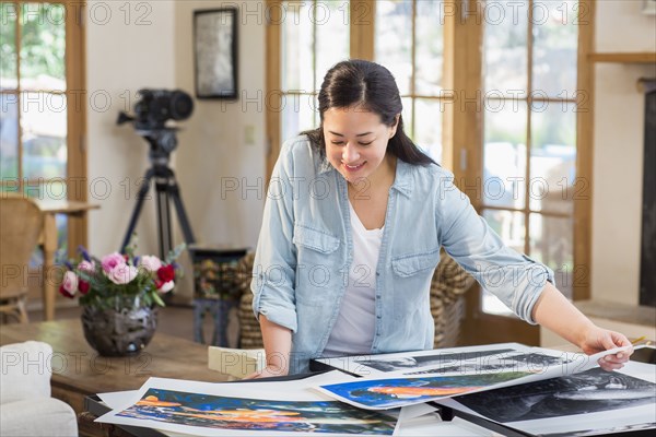 Mixed race photographer examining prints