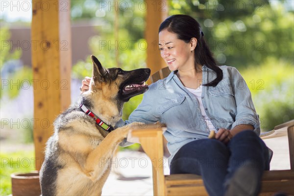 Mixed race woman petting dog