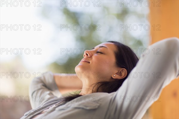 Mixed race woman relaxing on patio