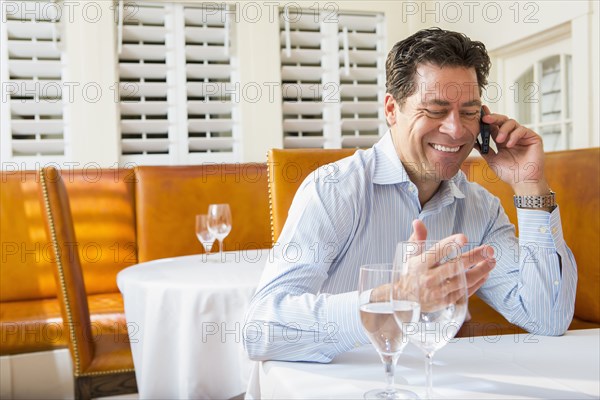 Caucasian businessman on cell phone at restaurant
