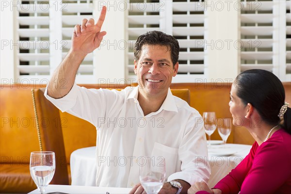 Couple calling waiter at restaurant