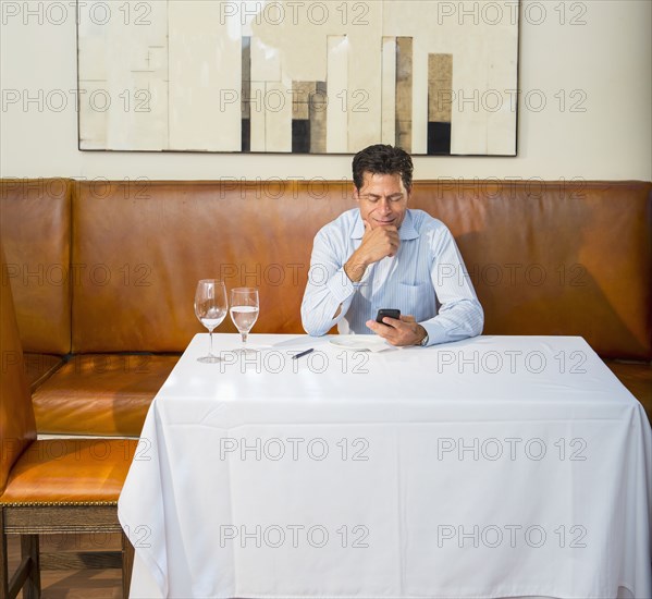 Caucasian businessman on cell phone at restaurant