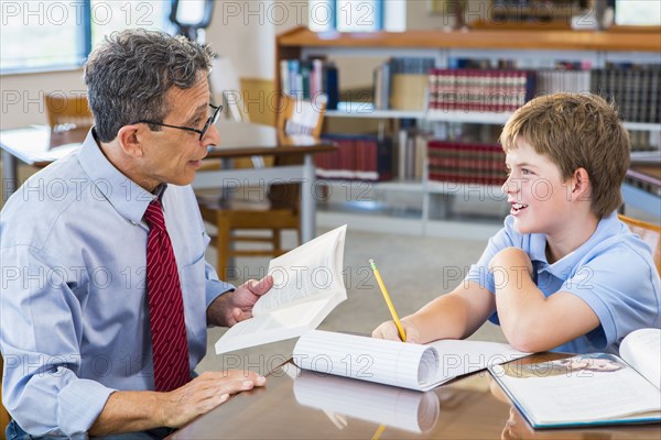 Teacher and student working in library