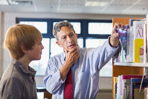 Teacher and student working in library