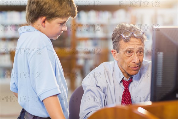 Teacher and student working at computer