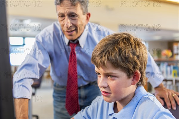 Teacher and student working at computer