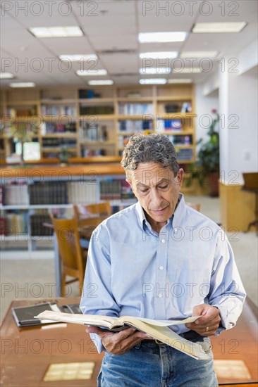 Senior man reading in library