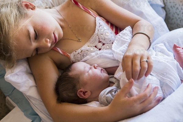 Caucasian girl holding newborn baby brother