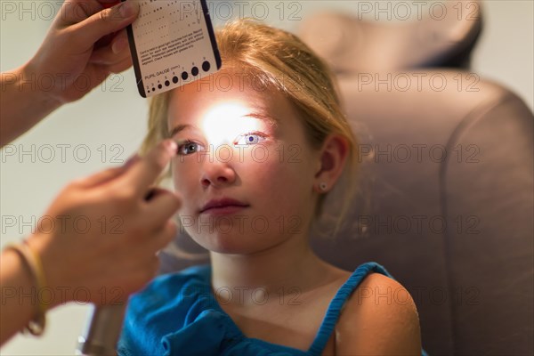 Caucasian girl receiving eye exam