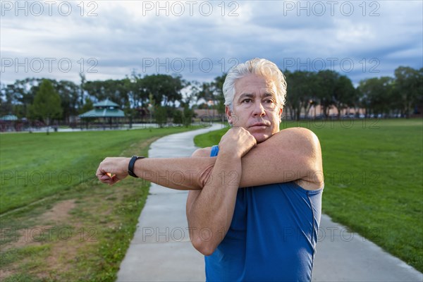 Hispanic man stretching in park