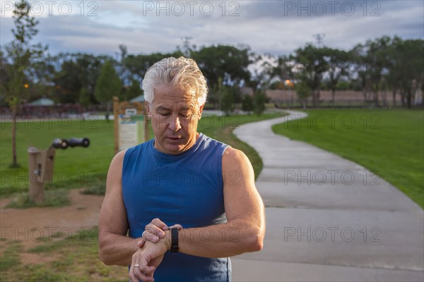 Hispanic man checking his watch in park