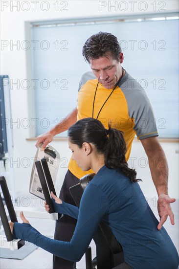 Woman working with personal trainer in gym