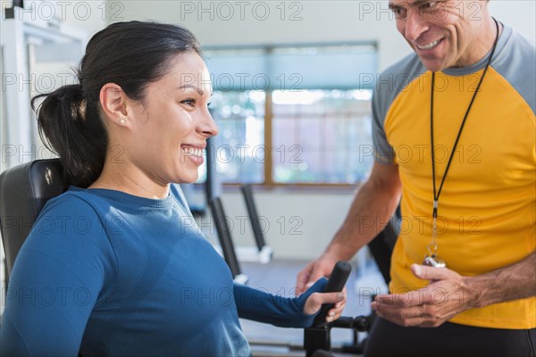 Woman working with personal trainer in gym