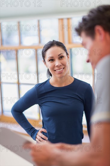 Man working with personal trainer in gym