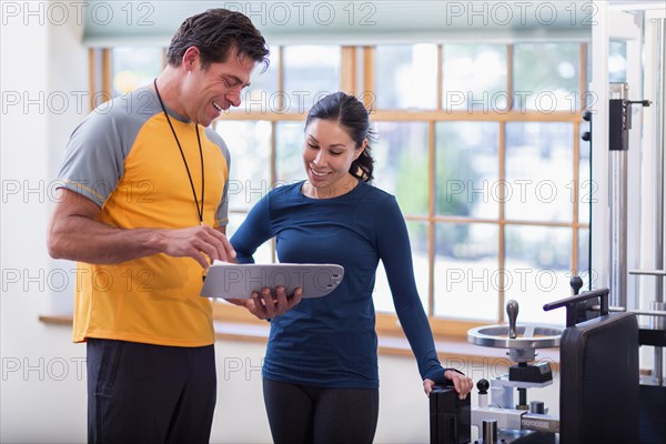 Woman working with personal trainer in gym