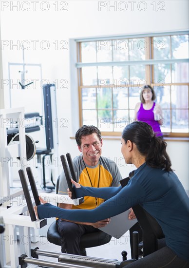 Woman working with personal trainer in gym