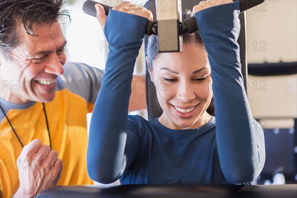 Woman working with personal trainer in gym