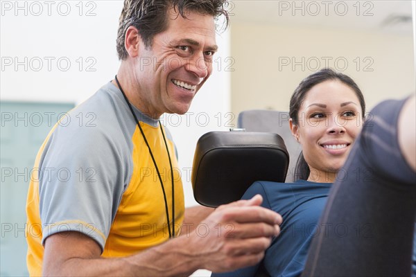 Woman working with personal trainer in gym