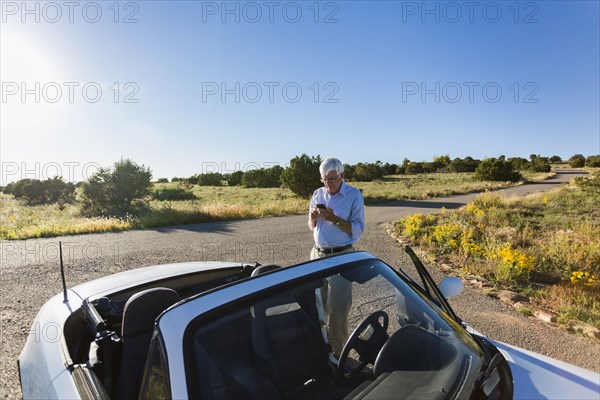 Senior Caucasian man walking to convertible