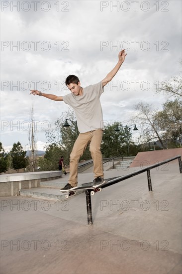 Mixed race boy skateboarding in park