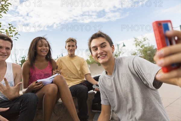 Teenagers taking self-portrait together outdoors