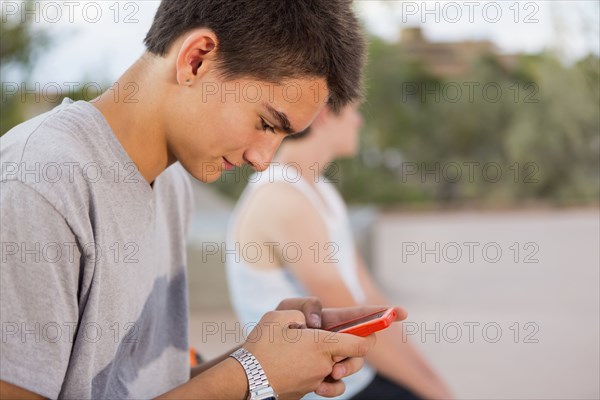 Caucasian boy using cell phone outdoors
