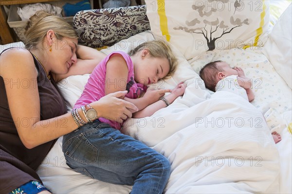 Caucasian family sleeping on bed