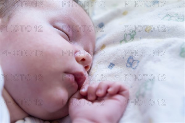 Caucasian newborn sleeping on bed